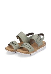 Sandales en daim vert avec un design de sangle tressée, boucle à la cheville et semelle texturée semblable à du liège. Caractérisées par une semelle extérieure en caoutchouc blanc pour le contraste.