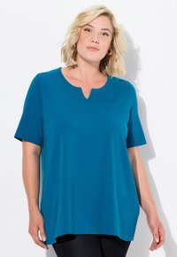 T-shirt s krátkým rukávem v barvě teal s výstřihem do V a volným střihem. Vyrobeno z měkké tkaniny s hladkou texturou, ideální pro každodenní nošení.