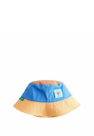 Zweifarbiger Eimerhut in Blau und Beige mit aufgenähtem Palmen-Motiv und kleinem grünem Etikett an der Seite vor weißem Hintergrund.