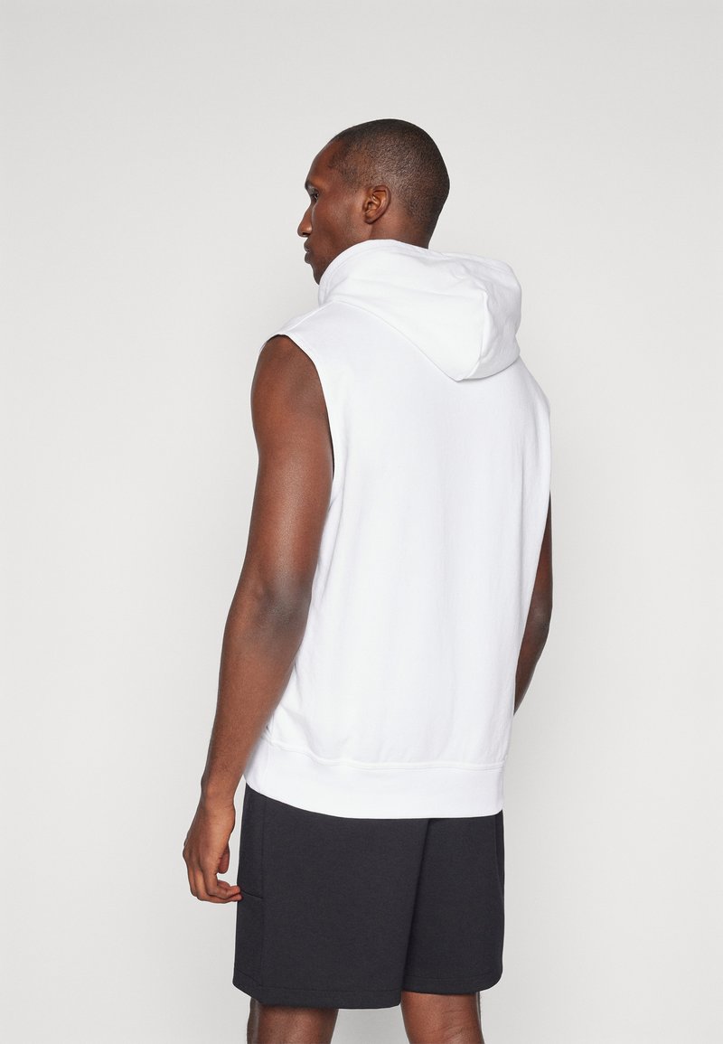 Weißer ärmelloser Kapuzenpullover mit Kordelzugkapuze, weichem Material und geripptem Saum, kombiniert mit dunklen Shorts. Schlichtes Design, keine sichtbaren Muster.
