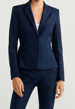 Navy blue tailored women's suit with two-button blazer and matching slim-fit trousers, worn with a white top underneath.