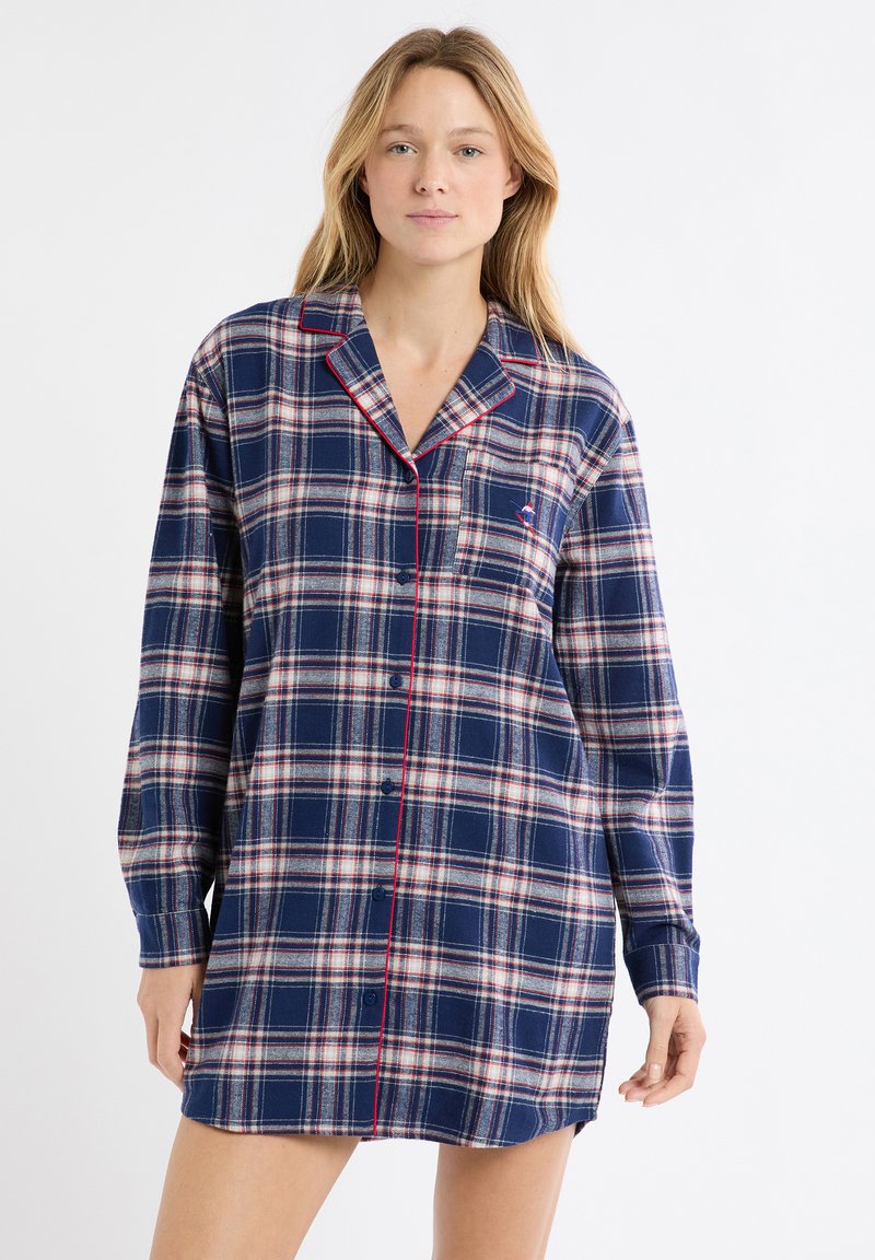 Camicia da notte in flanella scozzese blu navy con maniche lunghe, caratterizzata da piping rosso lungo il colletto e la patta dei bottoni, e un piccolo dettaglio di tasca sul petto.