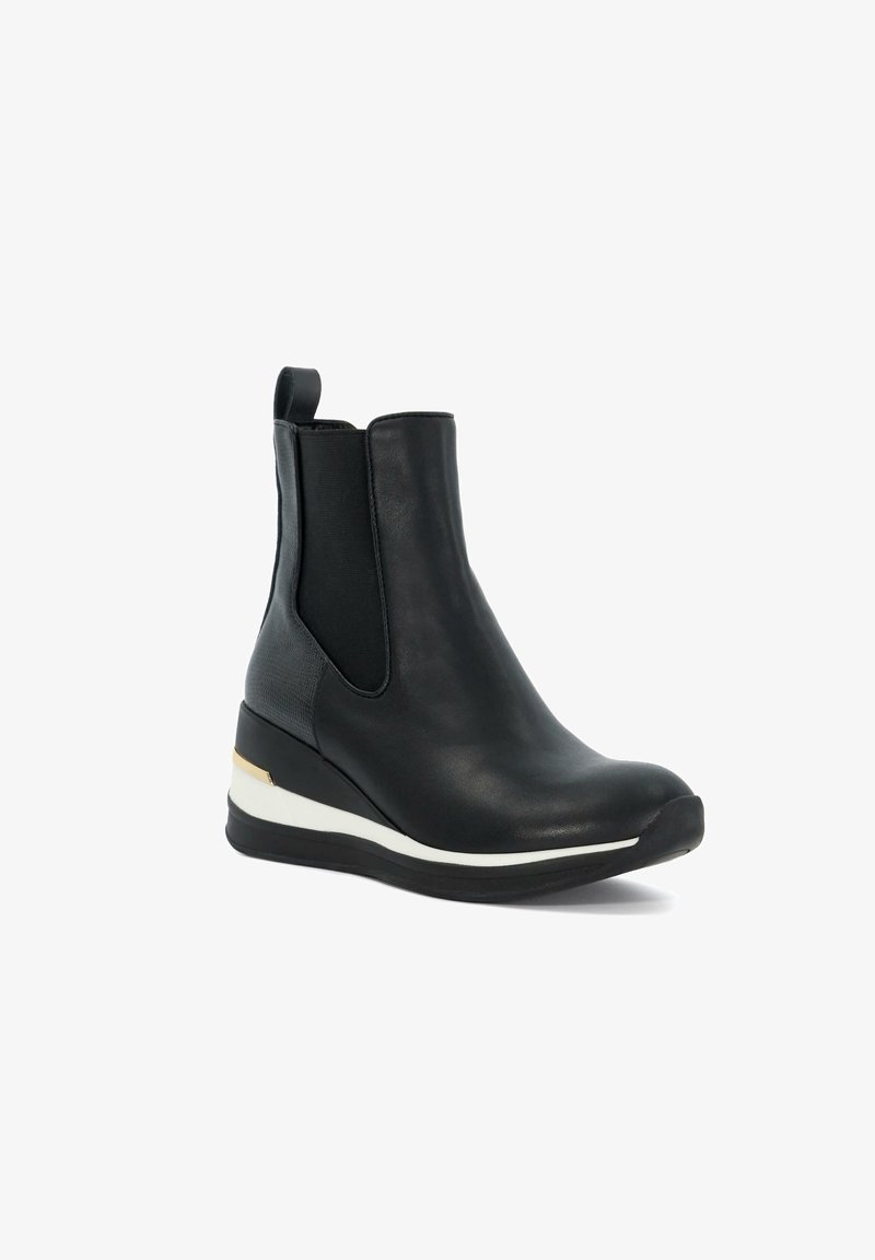 Botte cheville en cuir noir avec semelle compensée, panneaux latéraux élastiques, languette à l'arrière, et accents blancs et dorés sur la semelle.