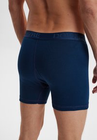 Marineblå boxer briefs i et blødt, strækbart stof. Har en flad talje med præget logo og kontraststing detaljer.