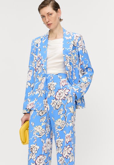 Blomsterpræget jakkesæt i et lyst blåt stof. Blazeren har en notch-lapel, og de vide bukser har et lignende design.