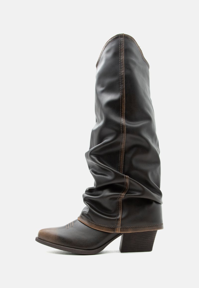 Botte de cowboy en cuir marron foncé, haute, avec un bout pointu, des coutures décoratives, une tige tombante et un talon bloc empilé sur fond blanc.