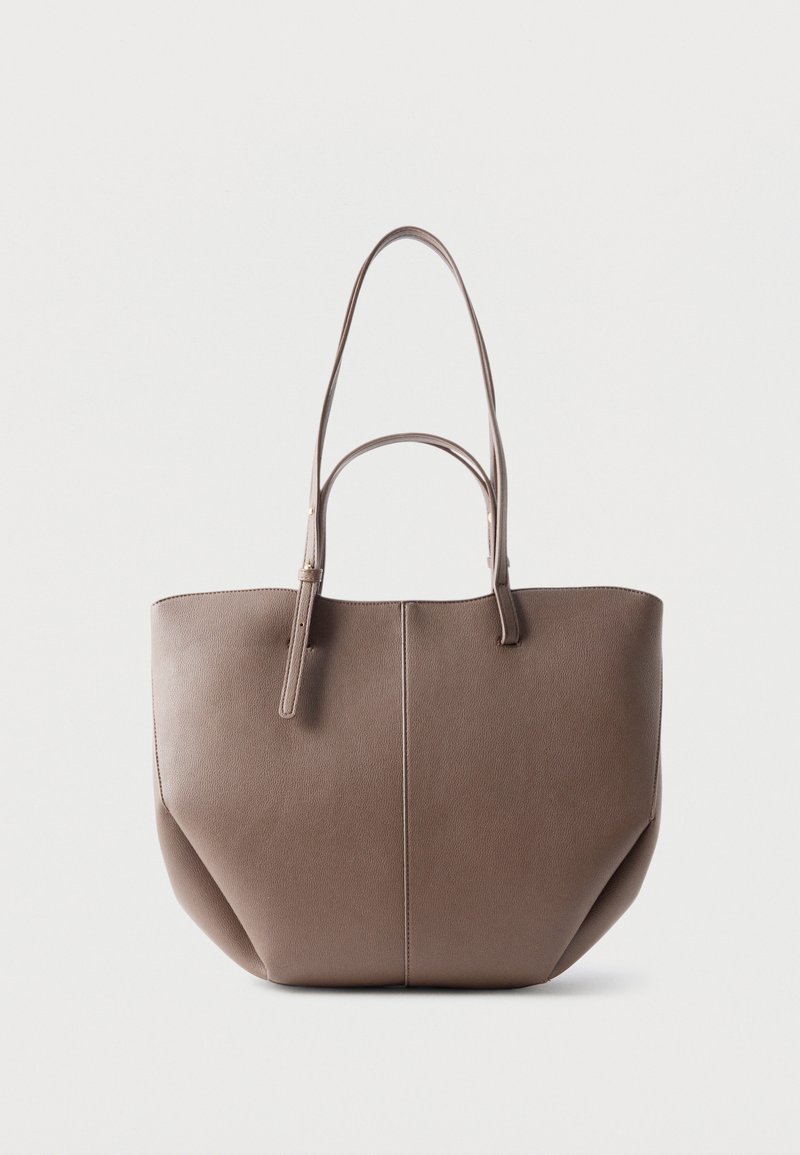 Sac cabas en cuir marron avec deux longues anses et une couture verticale simple au centre, sur un fond blanc uni.