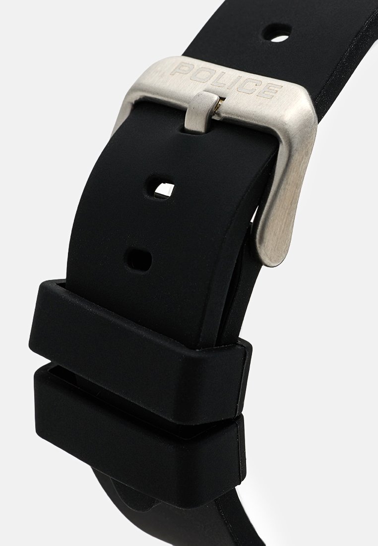 Correa de reloj de silicona negra con hebilla de plata cepillada grabada con "POLICE" y dos keepers rectangulares sobre un fondo claro.