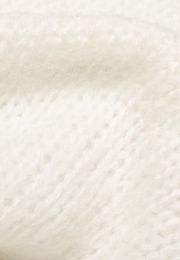 Biała dziana tkanina o miękkiej, teksturowanej powierzchni. Charakteryzuje się luźnymi ściegami i lekko puszystym wyglądem, co wskazuje na ciepło i komfort.