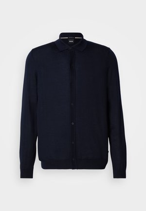 Marineblå cardigan laget av fint strikket materiale, med knappelukking foran, krage og lange ermer. Glatt tekstur med ribbede mansjetter og nederkant.