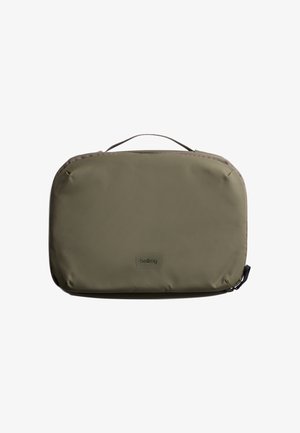 Sac rectangulaire vert olive en tissu durable, doté d'une poignée supérieure, d'une fermeture éclair et d'un logo de marque discret sur le devant.