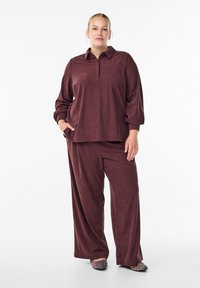 Maroon long-sleeve polo top with button placket and side pockets paired with matching wide-leg trousers, featuring a soft textured fabric.