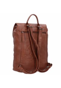 Sac à dos en cuir marron avec deux bretelles réglables, une poignée supérieure, une poche zippée à l'avant et un logo de lion en relief sur le côté.