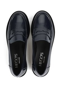 Granatowe lakierowane loafersy z tonowanym przeszyciem, okrągłym noskiem i czarną gumową podeszwą. Posiadają dekoracyjne wycięcie z przodu.