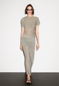 Gestreiftes Strickoberteil und passender Unterteil in Creme und Dunkelgrün, mit kurzen Ärmeln, einer figurbetonten Silhouette und einem dehnbaren Material.