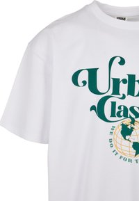 Fehér pamut póló, melyen zöld színű "Urban Classic" felirat található, alatta földgömb grafikával, sárga vonalak a szélességi és hosszúsági köröket ábrázolják.