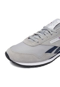 Grauer und marineblauer Reebok-Sneaker mit Obermaterial aus Wildleder und Stoff, grauen Schnürsenkeln, Markenlogo an der Seite und Zunge sowie schwarzer Gummisohle.