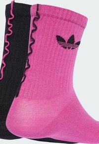 Due paia di calzini corti: tessuto nero con rifiniture a balze rosa e un calzino rosa con il logo Adidas nero. Materiale elastico; colori mescolati.