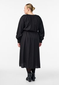 Czarna sukienka z długim rękawem, z marszczeniem przy dekolcie i wiązaniem w talii, wykonana z miękkiego, fakturowanego materiału, o zwiewnym kroju do kostek.