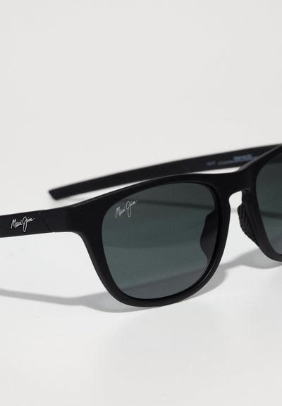 Czarne plastikowe okulary przeciwsłoneczne z ciemnymi soczewkami, o gładkiej teksturze i elastycznych zausznikach. Logo "Maui Jim" w białym kolorze po boku.