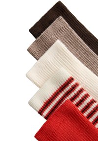 Cinq chaussettes en maille côtelée en brun, taupe, blanc, blanc avec des rayures rouges et noires, et rouge uni, empilées en diagonale sur un fond blanc.