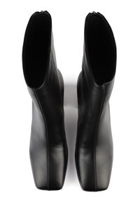 Bottes cheville en cuir noir à finition lisse, forme à bout carré et fermeture éclair latérale. Coutures visibles le long des côtés pour un détail supplémentaire.