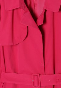 Abrigo de tela rosa con cuello, cierre de botones y un cinturón a juego con hebilla rectangular. Textura suave y corte ajustado.