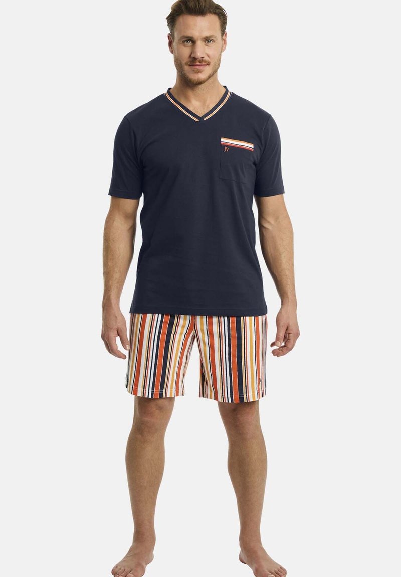 Marineblaues Baumwoll-V-Ausschnitt-T-Shirt mit einer gestreiften Tasche; kombiniert mit mehrfarbigen gestreiften Shorts in Orange, Marineblau und Weiß. Barfußhaltung.