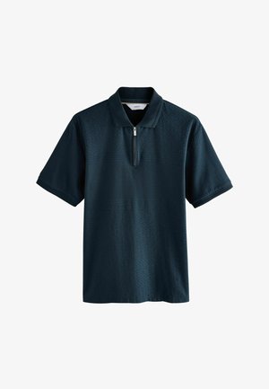 Tamsiai mėlynas polo marškinėliai su užtrauktuku ant kaklo, su tekstūruotu raštu ir trumpomis rankovėmis. Pagaminta iš švelnios, kvėpuojančios medžiagos.