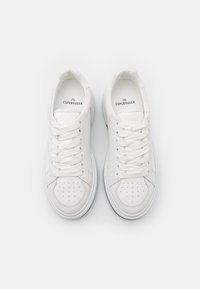 Baskets blanches avec une tige en cuir lisse, bout rond, détails perforés, lacets plats et logo à l'intérieur. Semelle en caoutchouc avec une texture minimale.
