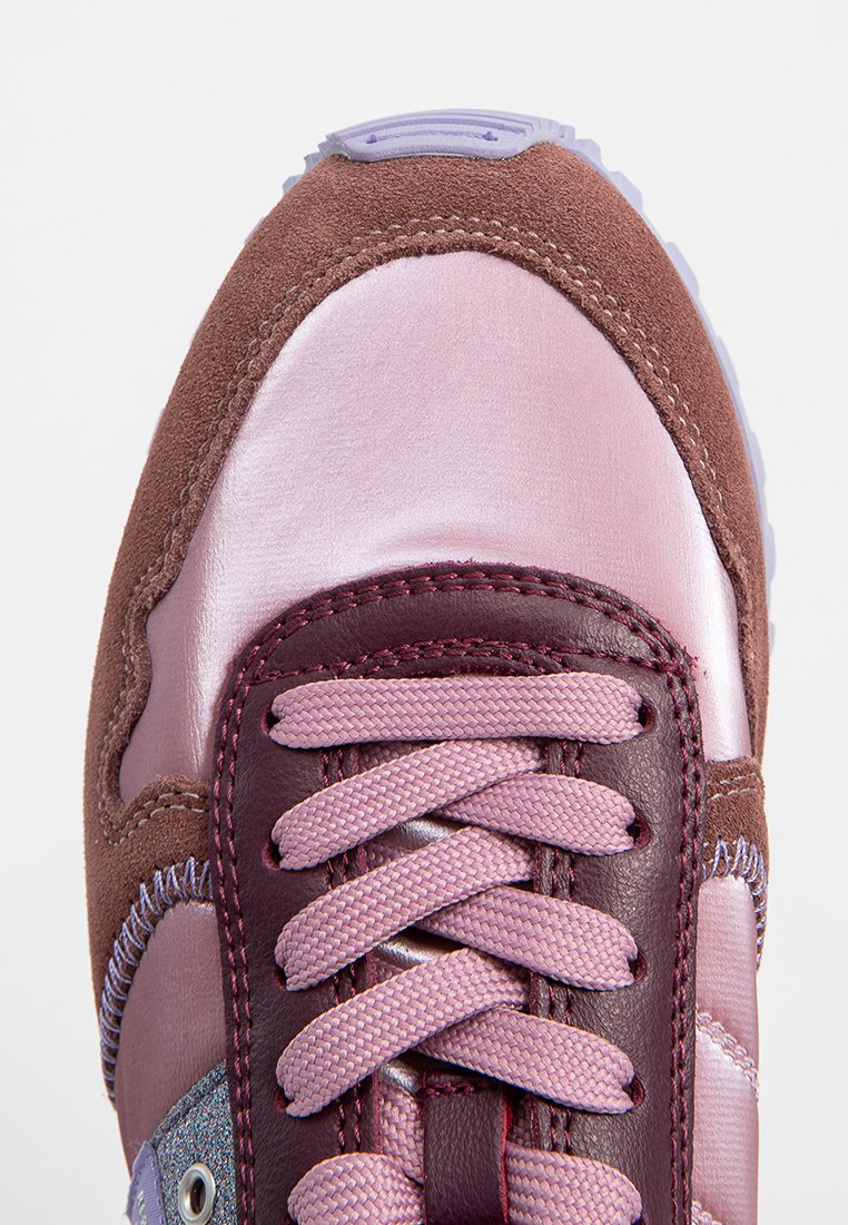 Scarpa sportiva con una tomaia in suede marrone, accenti rosa lucidi, lacci viola e linguetta testurizzata. Presenta una punta arrotondata e un collare imbottito.