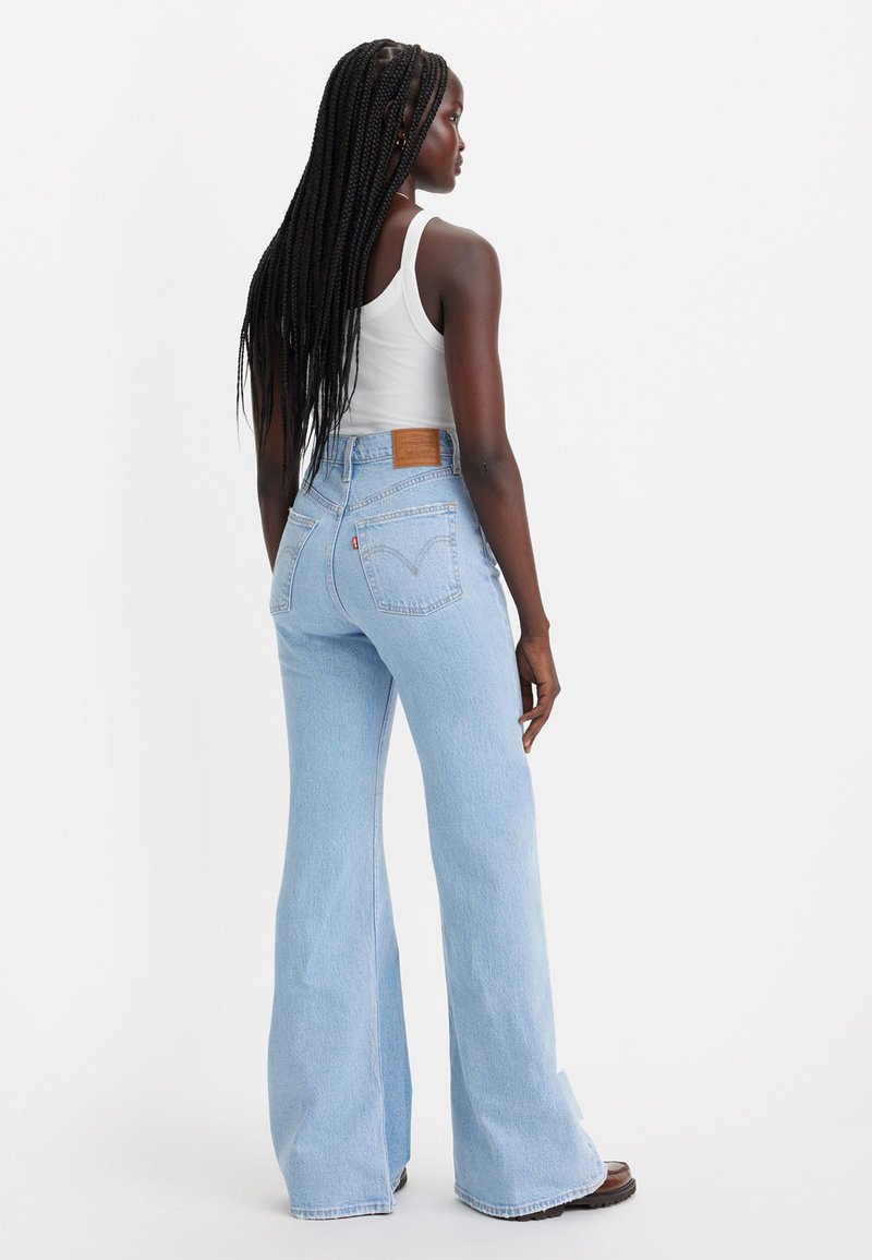 Helle blaue, weit geschnittene Jeans mit hoher Taille aus Denim. Zu den Merkmalen gehören ein Lederpatch auf der Rückseite und gestickte Gesäßtaschen.