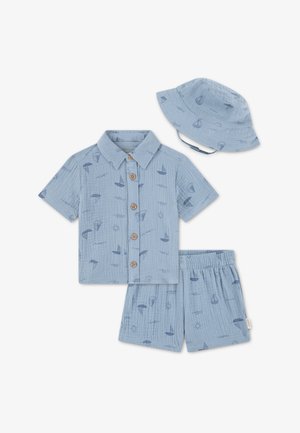 Šviesiai mėlyna marškinėliai su sagų užsegimu, trumpomis rankovėmis ir jūriniais raštais; derantys šortai ir kibiro formos skrybėlė; visi pagaminti iš minkštos, tekstūruotos medžiagos.