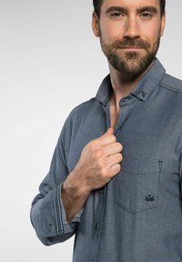 Grijze button-up shirt met een gestructureerd patroon, voorzien van een borstzak en contrasterende stiksels op de manchetten en kraag.