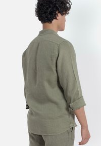 Licht olijfgroen linnen shirt met opgerolde mouwen, button-down kraag, losse pasvorm en een rechte zoom.