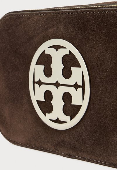 Brązowy zamszowy portfel z okrągłym srebrnym logo z przeplatającymi się kształtami. Projekt zawiera czyste linie i widoczne detale przeszyć.