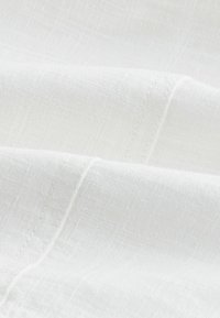 Vitt linne med en lätt textur, som har subtila vävda mönster och mjuka, andningsbara lager. Perfekt för lätta kläder eller inredningstextilier.