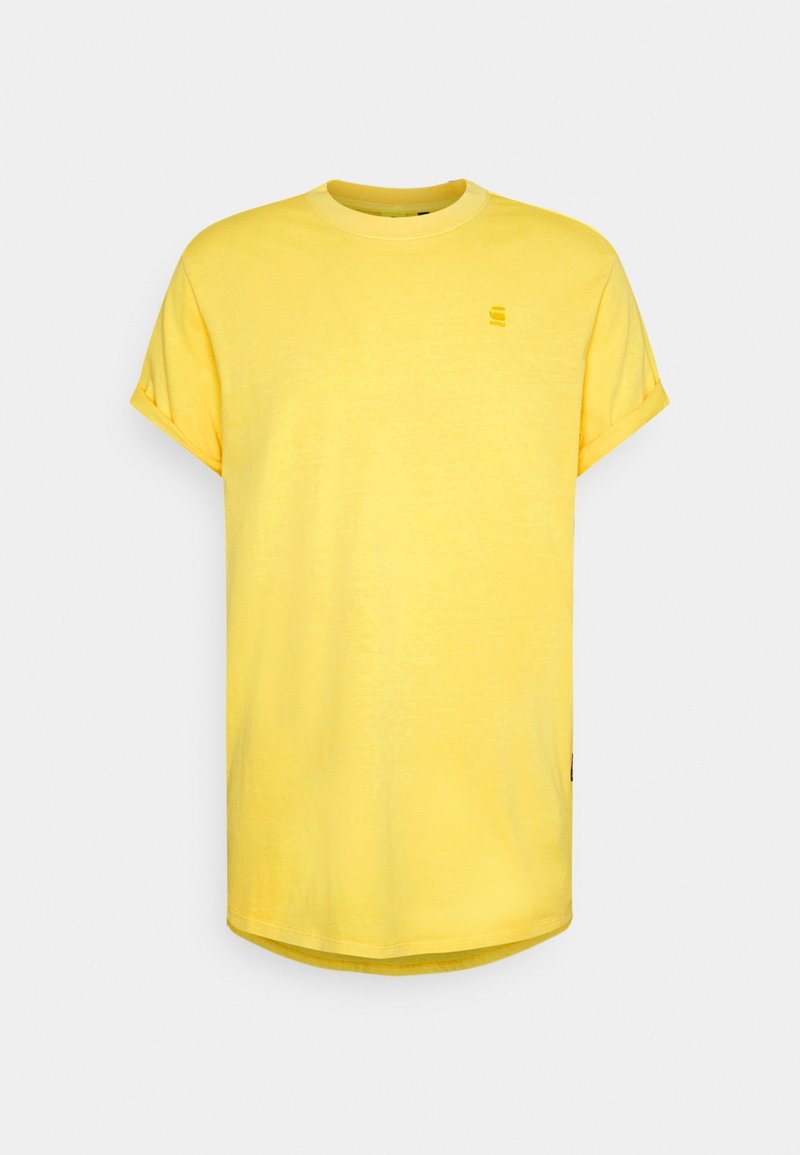 T-shirt en coton jaune à manches courtes retroussées, col rond et ourlet arrondi. Présente un petit logo sur la poitrine.