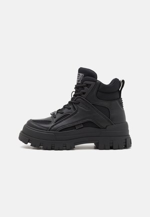 Sort høj top sneaker med tyk, robust sål, mesh og læder overdel, polstret krave og snørebånd foran.