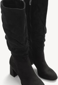 Svarta mocka knähöga stövlar har en rynkad design, en texturerad yta och en blockklack, med en dragkedja på sidan.