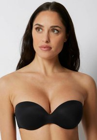 Sujetador negro sin tirantes con tela suave, que presenta un diseño sin costuras y una forma contorneada para mayor soporte. No tiene herrajes visibles ni adornos.