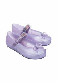 Scarpe piatte trasparenti viola con punta arrotondata, dettaglio decorativo a fiocco e una fascia elastica colorata attorno alla caviglia. Texture liscia.