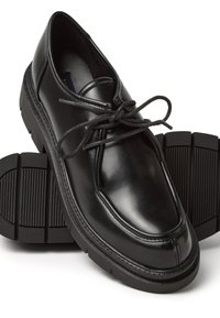 Scarpe stringate in pelle nera con punta rotonda, finitura liscia e suola in gomma spessa e testurizzata con scanalature orizzontali.