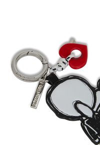 Portachiavi con un anello argentato, un accento a forma di cuore rosso, design di un personaggio dei cartoni animati in bianco e nero, e un piccolo tag argentato con la scritta "Karl Lagerfeld".