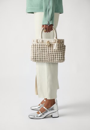 Audinė bežinė rankinė su struktūrizuota forma, turinti baltą odinę dirželį, auksinius aksesuarus ir tekstūruotą paviršių. Sidabro spalvos blokiniai kulniukai.