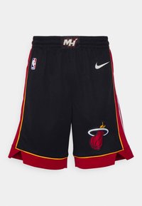 Shorts de basketball noirs Miami Heat avec bordure rouge et jaune, logos NBA et Nike, et un emblème d'équipe de basketball en flammes sur le devant.