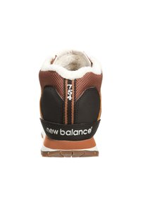 Brown and black sneaker with a textured upper, white fleece lining, and rubber sole. Features include brand logo and numeric detail.