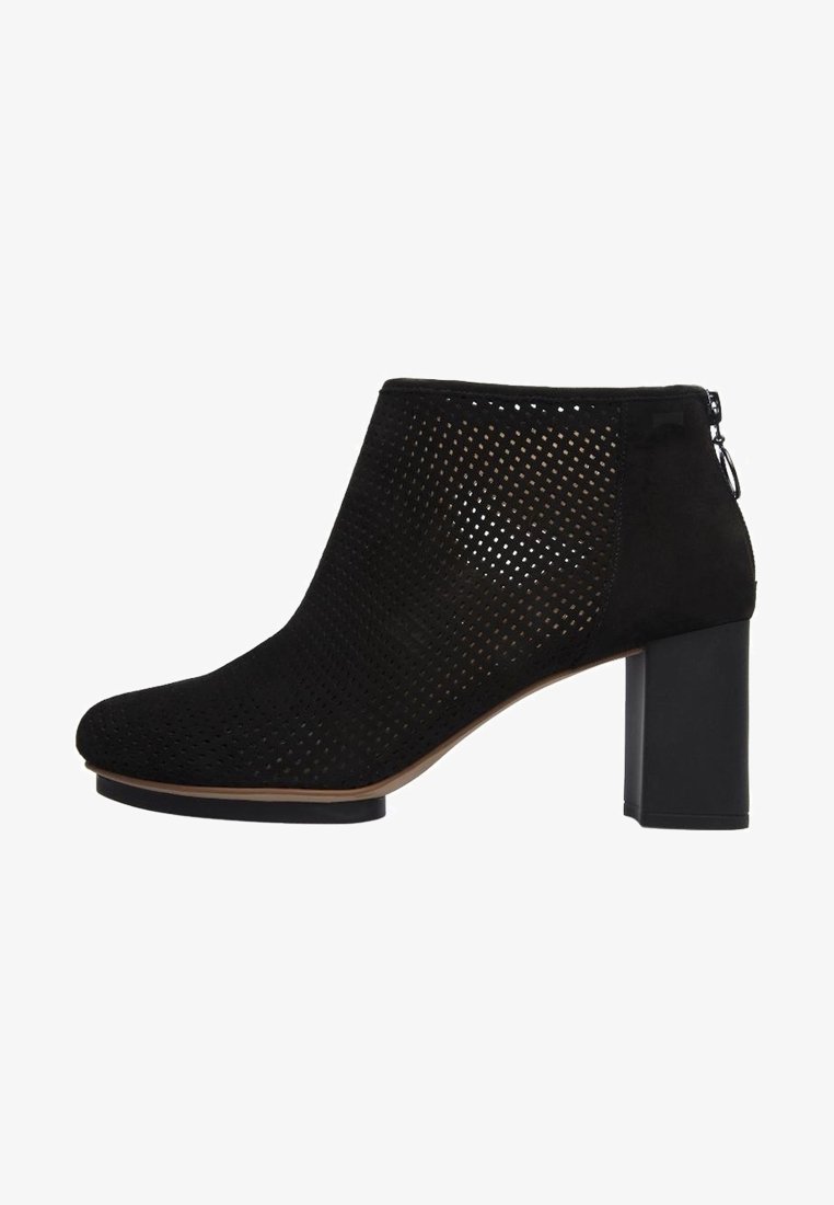 Bottine noire perforée avec talon bloc et fermeture éclair à l'arrière, conçue pour la mode et le confort des femmes.