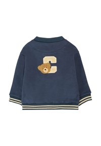 Felpa navy con colletto rotondo, dotata di una patch a forma di orso e una grande lettera "C" in beige. Polsini e orlo a righe. Texture morbida.