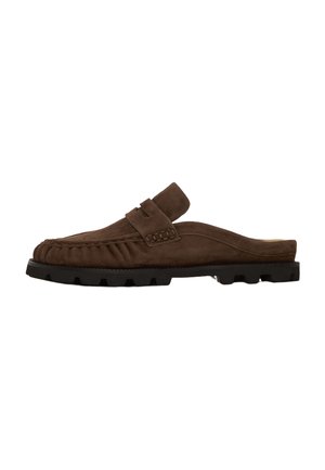 Brun ruskinds slip-on mule loafer med syninger og sort robust gummisål, set fra siden på hvid baggrund.